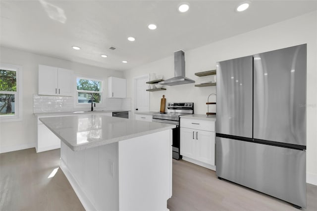 kitchen featuring stainless steel appliances, extractor fan, plenty of natural light, and a kitchen island