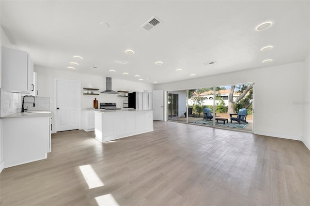 unfurnished living room with light hardwood / wood-style floors and sink