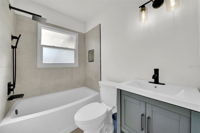 full bathroom featuring tiled shower / bath, vanity, and toilet