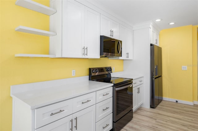 kitchen featuring white cabinetry, light wood-type flooring, light stone countertops, and appliances with stainless steel finishes