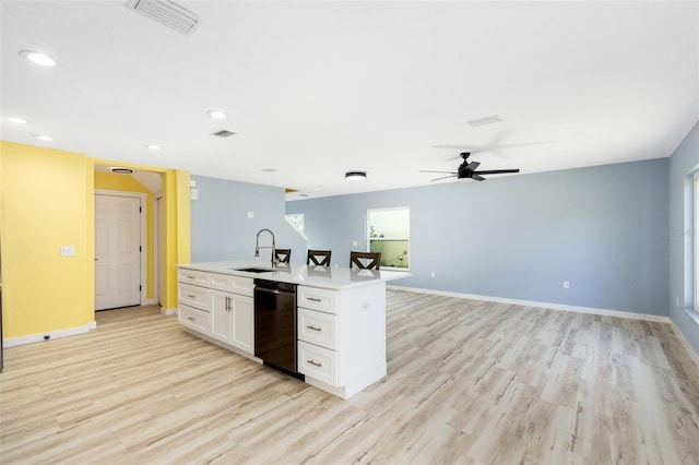 kitchen featuring sink, dishwasher, white cabinetry, light hardwood / wood-style floors, and a center island with sink