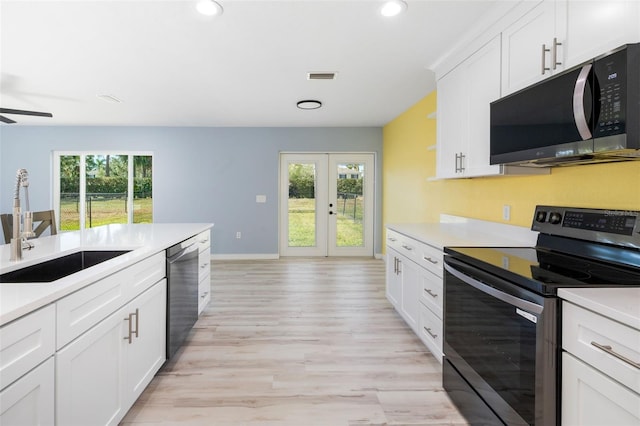 kitchen with a healthy amount of sunlight, stainless steel appliances, sink, and white cabinets