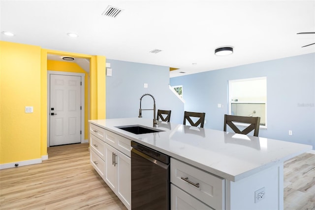 kitchen with white cabinetry, dishwasher, sink, a kitchen island with sink, and light hardwood / wood-style flooring