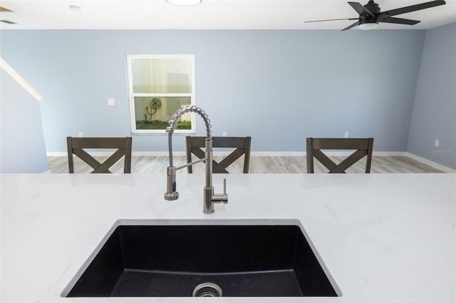 kitchen with ceiling fan, sink, and light wood-type flooring