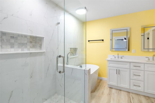 bathroom with vanity and shower with separate bathtub