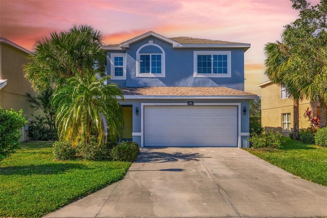 view of front of property with a garage and a lawn