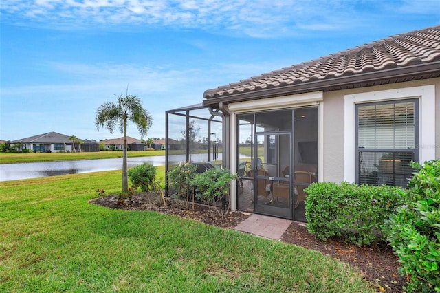 view of yard with a sunroom and a water view