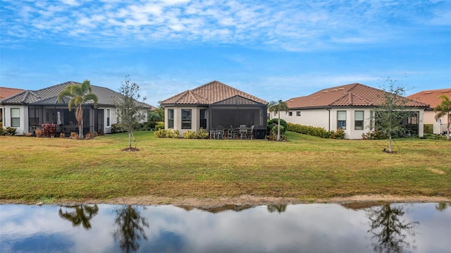 rear view of house featuring a water view and a yard