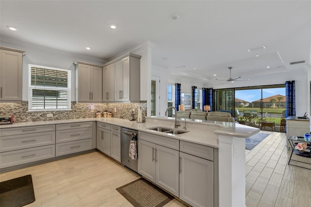 kitchen with kitchen peninsula, light wood-type flooring, stainless steel dishwasher, gray cabinetry, and sink