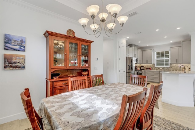 dining area featuring light hardwood / wood-style floors, an inviting chandelier, and ornamental molding