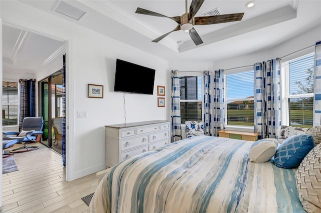 bedroom featuring a tray ceiling, light hardwood / wood-style flooring, ceiling fan, and ornamental molding