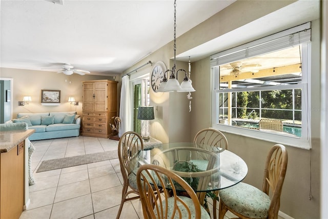 tiled dining room with ceiling fan with notable chandelier