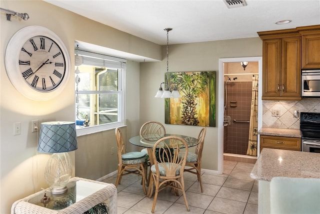 tiled dining space featuring a chandelier