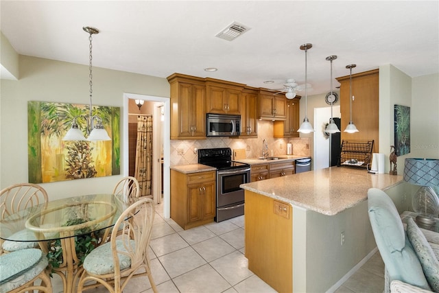 kitchen featuring sink, kitchen peninsula, hanging light fixtures, and appliances with stainless steel finishes