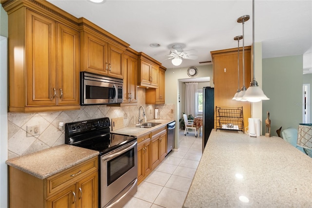 kitchen with stainless steel appliances, ceiling fan, sink, light tile patterned floors, and decorative light fixtures