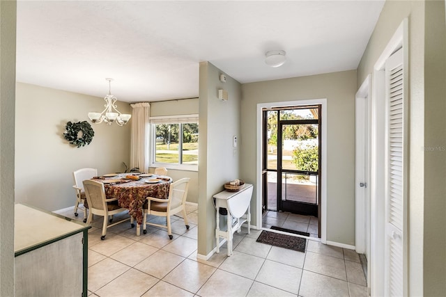 entryway featuring a wealth of natural light, light tile patterned floors, and a notable chandelier