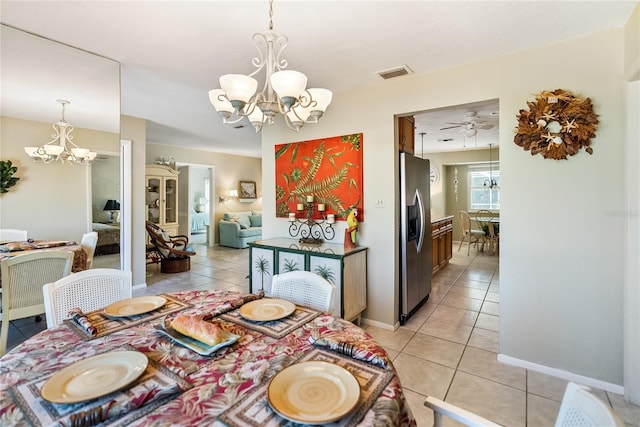 tiled dining area with ceiling fan with notable chandelier