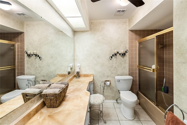 full bathroom with tile patterned flooring, a textured ceiling, combined bath / shower with glass door, toilet, and vanity