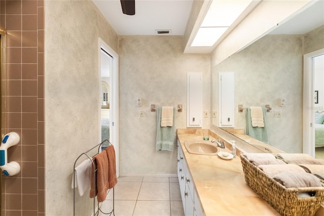 bathroom with tile patterned floors, vanity, and a wealth of natural light