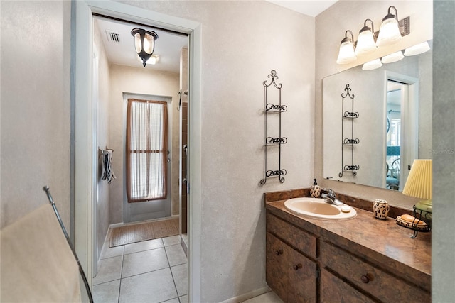 bathroom with tile patterned flooring, vanity, and a wealth of natural light