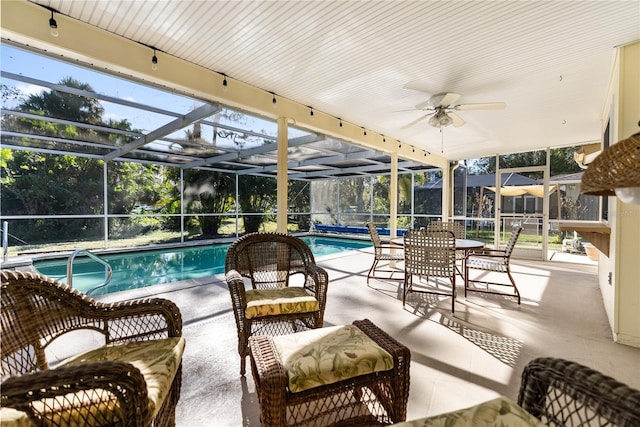 view of swimming pool with glass enclosure, ceiling fan, and a patio