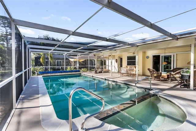 view of pool with glass enclosure and a patio area