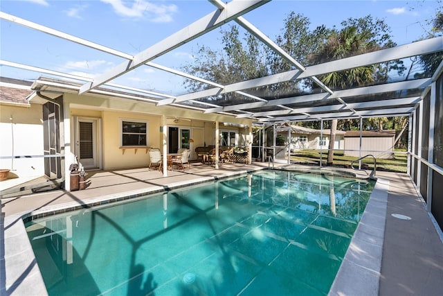 view of pool featuring glass enclosure, ceiling fan, and a patio area