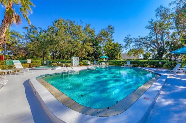 view of pool with a patio area and a hot tub