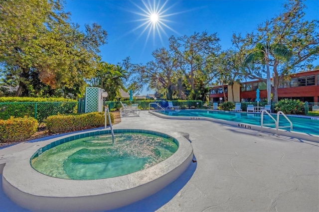 view of swimming pool featuring a hot tub