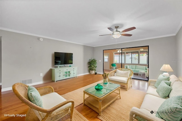 living room with hardwood / wood-style flooring, ceiling fan, and crown molding