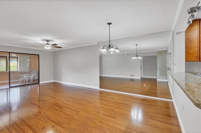 unfurnished living room with a textured ceiling, light hardwood / wood-style flooring, ceiling fan with notable chandelier, and ornamental molding