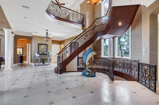 interior space with decorative columns, ceiling fan, and ornamental molding