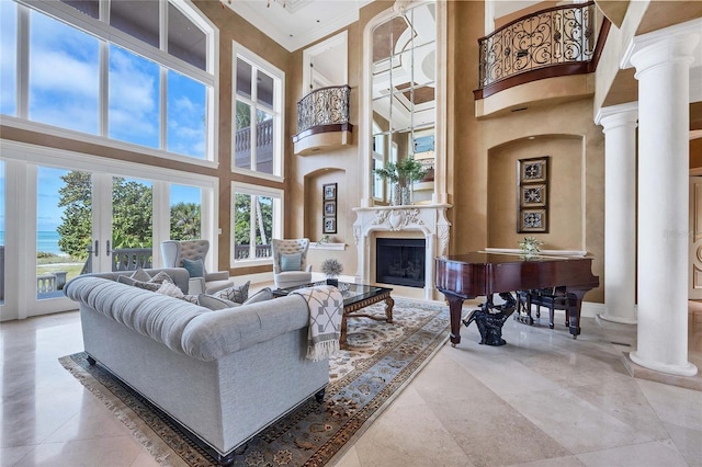 living room with decorative columns, a towering ceiling, and a premium fireplace