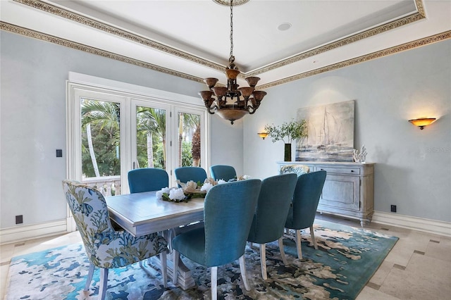 dining area with a raised ceiling, an inviting chandelier, and ornamental molding