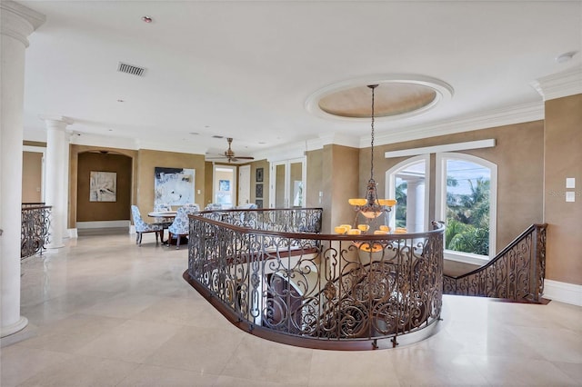 hallway with a notable chandelier, ornamental molding, and ornate columns