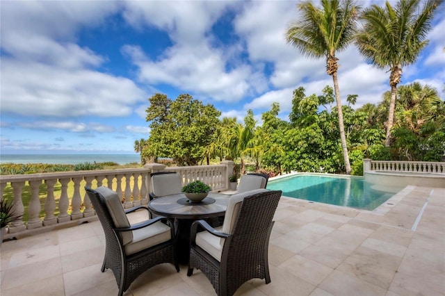 view of pool with a water view and a patio