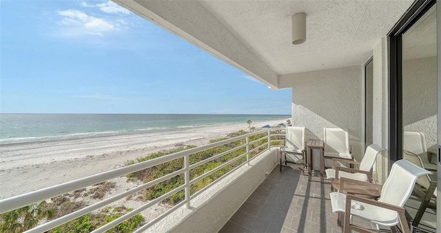 balcony featuring a water view and a view of the beach