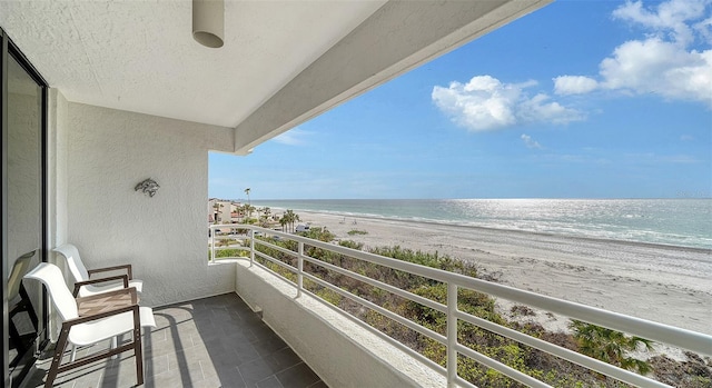 balcony with a water view and a beach view