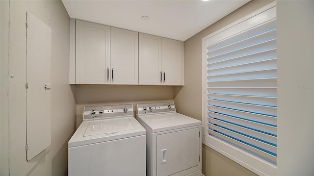 clothes washing area featuring washer and clothes dryer and cabinets