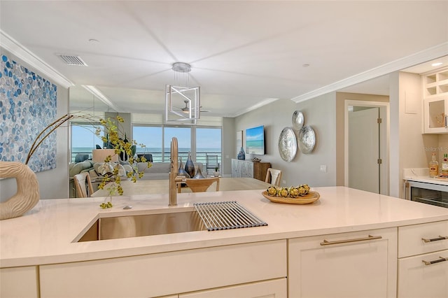 2105 Gulf Of Mexico Dr Unit 3303, Longboat Key, FL 34228 - kitchen featuring open floor plan, ornamental molding, light countertops, and white cabinetry