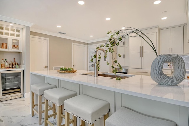 2105 Gulf Of Mexico Dr Unit 3303, Longboat Key, FL 34228 - kitchen featuring beverage cooler, recessed lighting, light marble finish floors, a kitchen breakfast bar, and crown molding