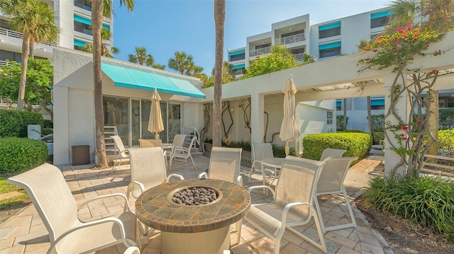 2105 Gulf Of Mexico Dr Unit 3303, Longboat Key, FL 34228 - view of patio featuring outdoor dining area and a fire pit