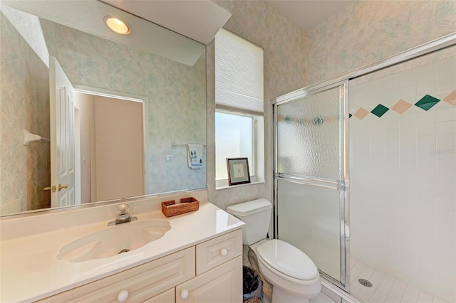 bathroom featuring vanity, toilet, and walk in shower