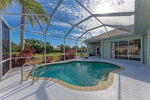 view of pool with glass enclosure and a patio