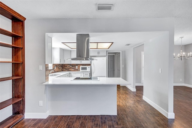 kitchen with kitchen peninsula, white appliances, and dark wood-type flooring