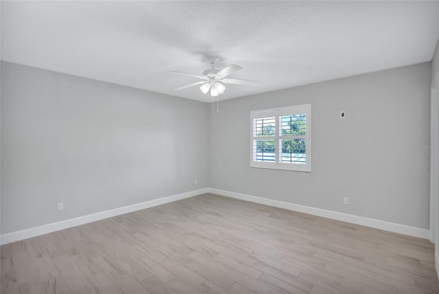 spare room with ceiling fan, light hardwood / wood-style flooring, and a textured ceiling