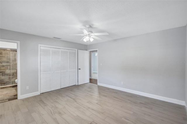 unfurnished bedroom with ceiling fan, light hardwood / wood-style floors, connected bathroom, and a closet