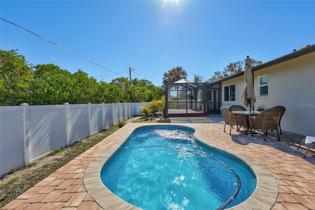 view of swimming pool featuring a lanai and a patio