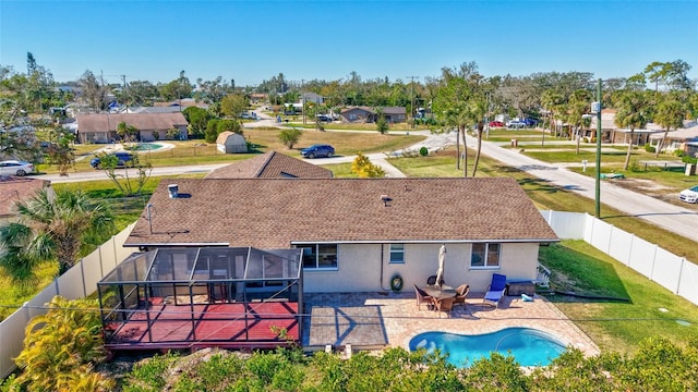 rear view of property featuring a fenced in pool, a patio area, and a yard