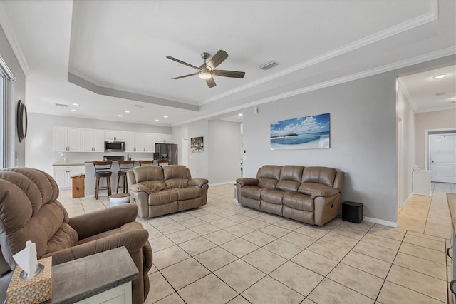 tiled living room featuring ceiling fan, crown molding, and a tray ceiling